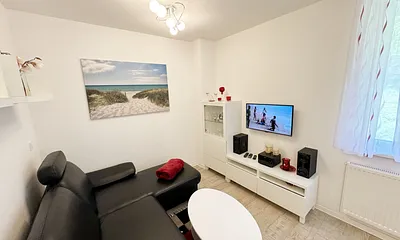 Wohnbereich mit gemütlicher Couch, LCD-TV, DVD-Player und einer Musikanlage mit USB und Iphone/IPod Dock Station