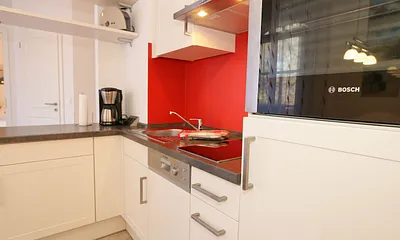 Küchenzeile mit Backofen, 2 Zonen-Ceranfeld, Spülmaschine, Kühlschrank mit Gefrierfach, Kaffeemaschine, Wasserkocher, Toaster und praktischen Kochutensilien