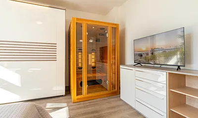 1. Schlafzimmer mit Doppelbett, Zugang zum Balkon und Infrarotsauna