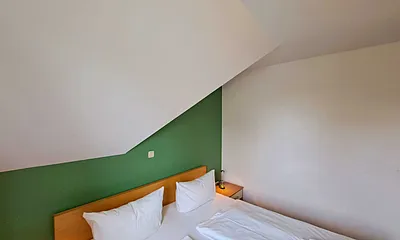 Schlafzimmer mit Doppelbett und Kleiderschrank