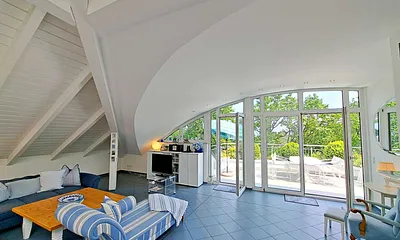 großzügiger Wohn- und Essbereich mit Leseecke, Kamin, Esstisch und offener Küche