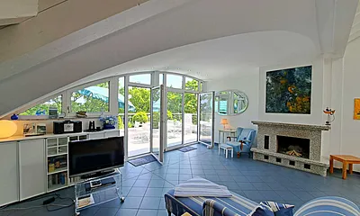 großzügiger Wohn- und Essbereich mit Leseecke, Kamin, Esstisch und offener Küche