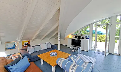 großzügiger Wohn- und Essbereich mit Leseecke, Kamin, Esstisch und offener Küche