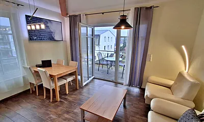 Wohn- und Essbereich mit gemütlicher Couch, Esstisch, Küchenzeile und Zugang zum Balkom