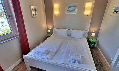 Schlafzimmer mit Doppelbett und zweitem Flachbild-TV