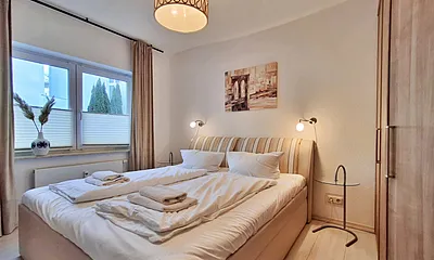 Schlafzimmer mit Doppelbett, Kleiderschrank und zusätzlichem TV