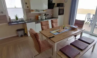 Wohn- und Essbereich mit gemütlicher Couch, Küchenzeile, Zugang zur Hochterrasse