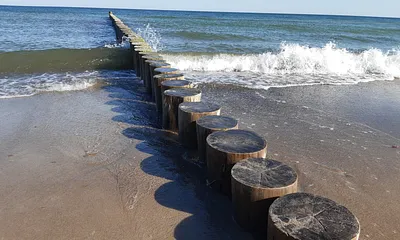 Wasser brandet an die Buhnen