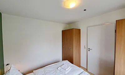 Schlafzimmer mit Doppelbett und Kleiderschrank