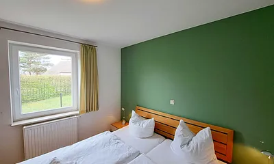 Schlafzimmer mit Doppelbett und Kleiderschrank