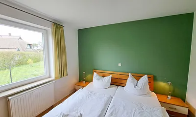 Schlafzimmer mit Doppelbett und Kleiderschrank