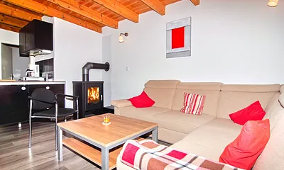 Wohnzimmer mit Schlafsofa und Kaminofen