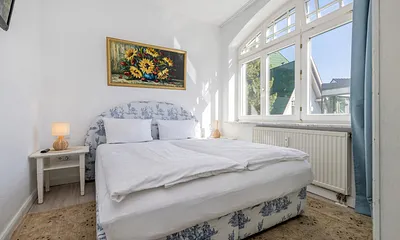 Schlafzimmer 1 mit Doppelbett, Kleiderschrank und TV.