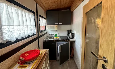 kleine Kochnische mit Kühlschrank, Kaffeemaschine, Mikrowelle, Cerankochfeld