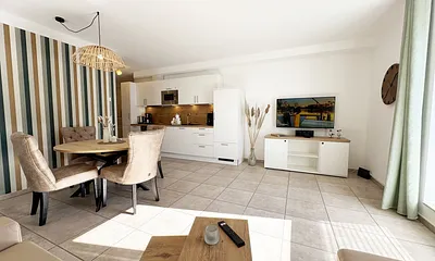 gemütlicher Wohnbereich mit angrenzender Küchenzeile und Esstisch