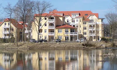 Idyllische Süd-Ansicht des Dünenschlosses mit Blick auf einen kleinen See & den Stadtwald