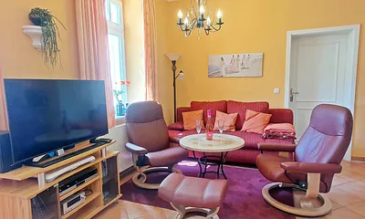 Gemütlicher Sitzbereich im Wohnzimmer (Stuck, hohe Decken und der Kronleuchter vermitteln eine Art Schlossatmosphäre)