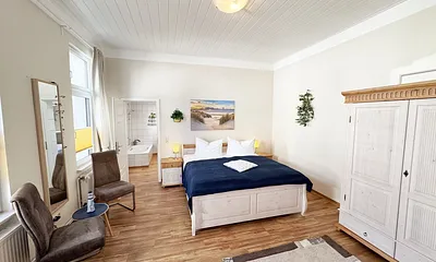 Schlafzimmer mit Doppelbett und Blick ins Badezimmer