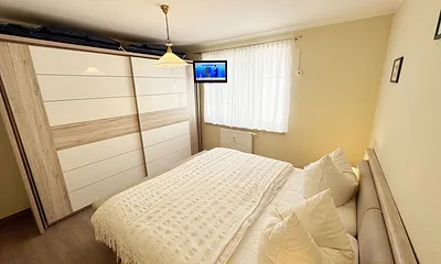 Schlafzimmer mit Doppelbett und Kleiderschrank