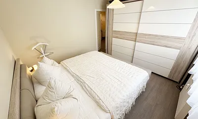 Schlafzimmer mit Doppelbett und Kleiderschrank