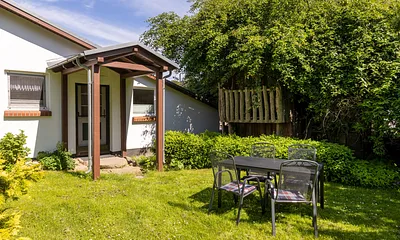 Ihre sonnige Sitzgelegenheit vorm Ferienhaus - gern dürfen Sie hier grillen. 