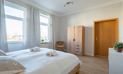 Das erste Schlafzimmer mit Doppelbett und Kleiderschrank