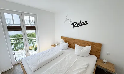 Schlafzimmer mit Doppelbett und Zugang auf den Balkon