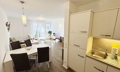 gemütlicher Wohnbereich mit Küchenzeile sowie Esstisch mit Stühlen