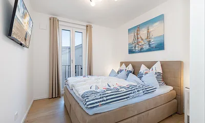 Schlafzimmer mit Doppelbett und Smart-TV