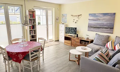 heller Wohnbereich mit Bücherregal sowie Brettspiele