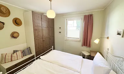 Schlafzimmer mit Doppelbett, sowie Nachtischablagen mit Beleuchtung