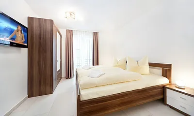 Das 2. Schlafzmmer mit Doppelbett, Kleiderschrank und TV. Bügelbrett und Bügeleisen sind vorhanden.