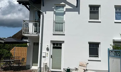 Blick auf die 3-geschossige Viertelhaushälfte, ein Teilstück des Garten und die Haustür