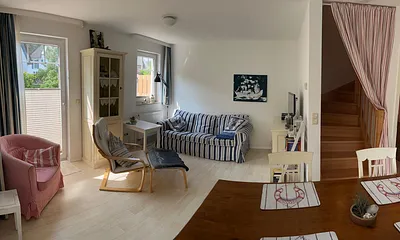 Wohnzimmer, rechtsseitig führt eine Massivholz-Treppe in die beiden oberen Etagen