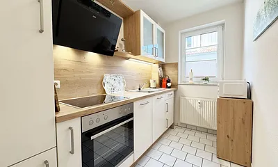 separate Küche mit Cerankochfeld, Backofen und vielen kleinen Helfern