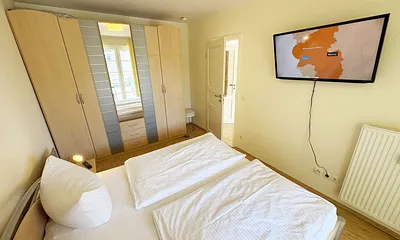 Schlafzimmer mit Doppelbett und Kleiderschrank