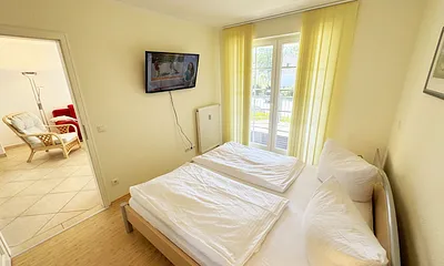 Schlafzimmer mit Doppelbett und TV