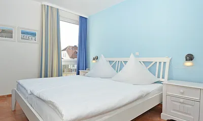 Schlafzimmer mit Doppelbett und Nachttischablagen