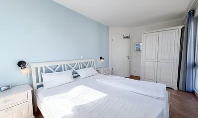 Schlafzimmer mit Doppelbett und Kleiderschrank