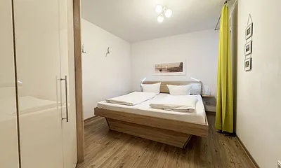 Schlafzimmer mit Doppelbett und Kleiderschrank