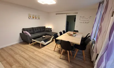 Wohnzimmer mit Schlafcouch und Essbereich