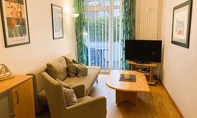 Der Wohnbereich mit Austritt zum möblierten Balkon.