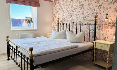 Das Schlafzimmer mit romantischen Tapeten ...