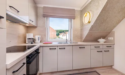 Die moderne Küchenzeile mit Geschirrspüler, Backofen, Ceranfeld, Mikrowelle, KühlgefrierKombination, Kaffeemaschine, Toaster und Wasserkocher.