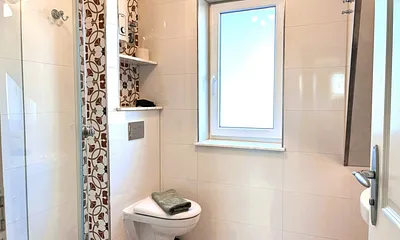 Das Bad mit einem Stück Dachschräge, schönen Vintagefliesen ...