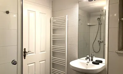 Das moderne Bad mit Echtglasdusche, WC, Fön und Fenster.