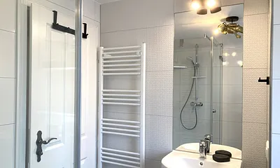 Das moderne Bad mit Echtglasdusche, WC, Fön und Fenster.