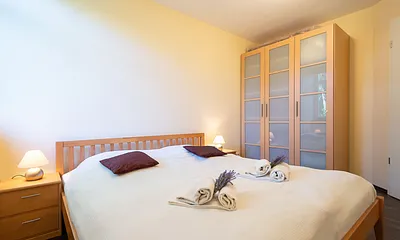 Das erste Schlafzimmer mit Doppelbett und großem Kleiderschrank