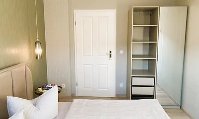 Der Kleiderschrank hat einen großen Spiegel und ausreichend Kleiderbügel.