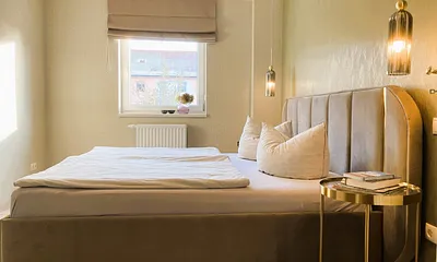 Das schöne Schlafzimmer hat ein Raffrollo mit Verdunkelungsfunktion.